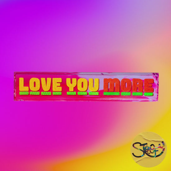 Video of Stoofy's hand-painted “Love You More” sign with bold lettering and vibrant colours on wood by artist, Stoofy. Human-made, maximalist contemporary art for people with expressive interiors