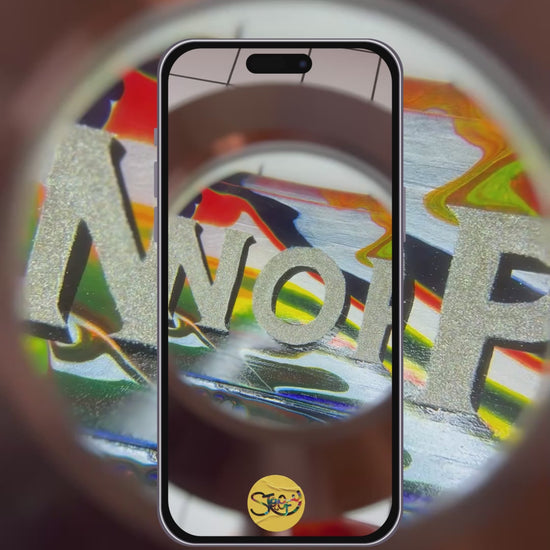 Stoofy - video capturing Hand-painted 'NOPE TO TAUPE' sign being looked at underneath a magnifying glass, highlighting its bold, colourful, glittery lettering, background and shiny gloss finish. Maximalist cotemporary art that makes a statement