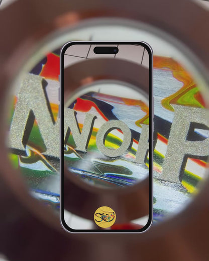 Stoofy - video capturing Hand-painted 'NOPE TO TAUPE' sign being looked at underneath a magnifying glass, highlighting its bold, colourful, glittery lettering, background and shiny gloss finish. Maximalist cotemporary art that makes a statement